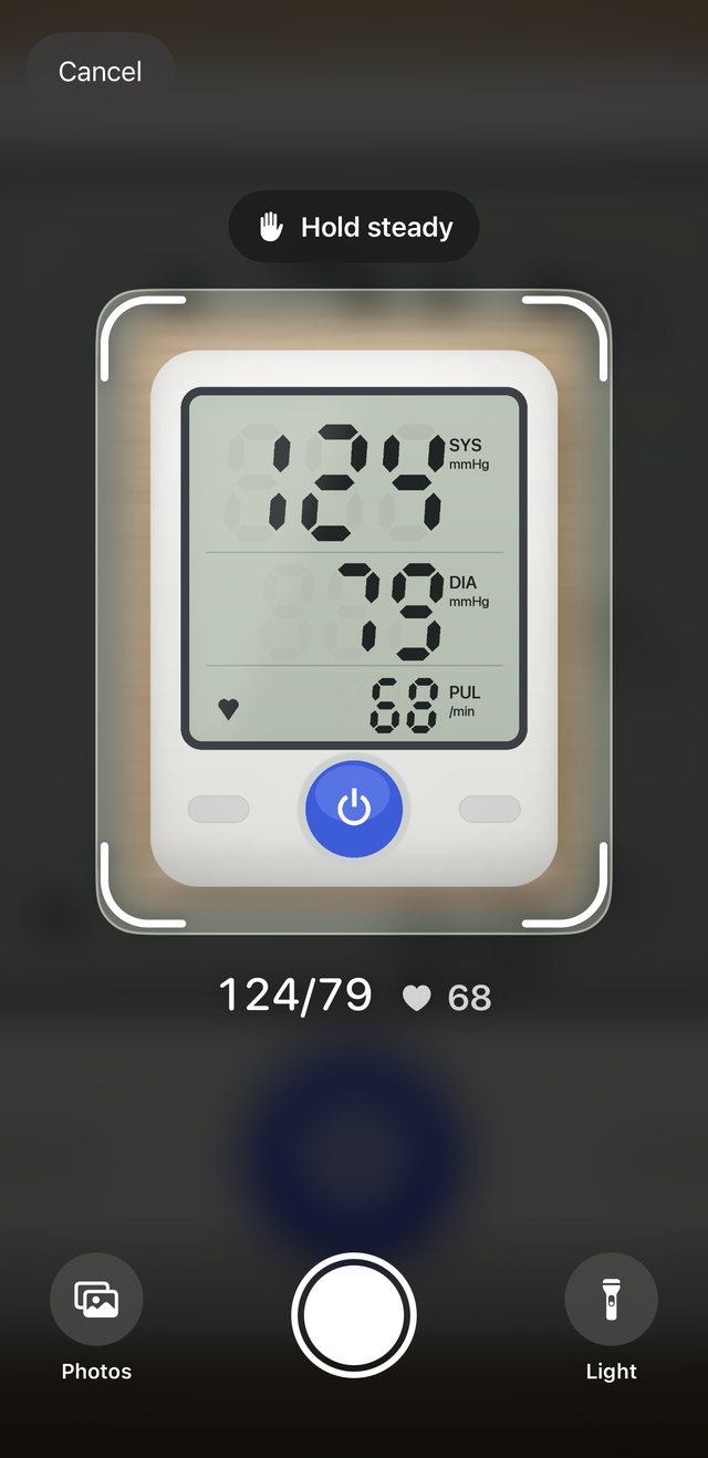 Corino’s Scan screen: a blood pressure monitor’s display inside the camera frame, read as 124 over 79 with a pulse of 68, ready to check before saving.